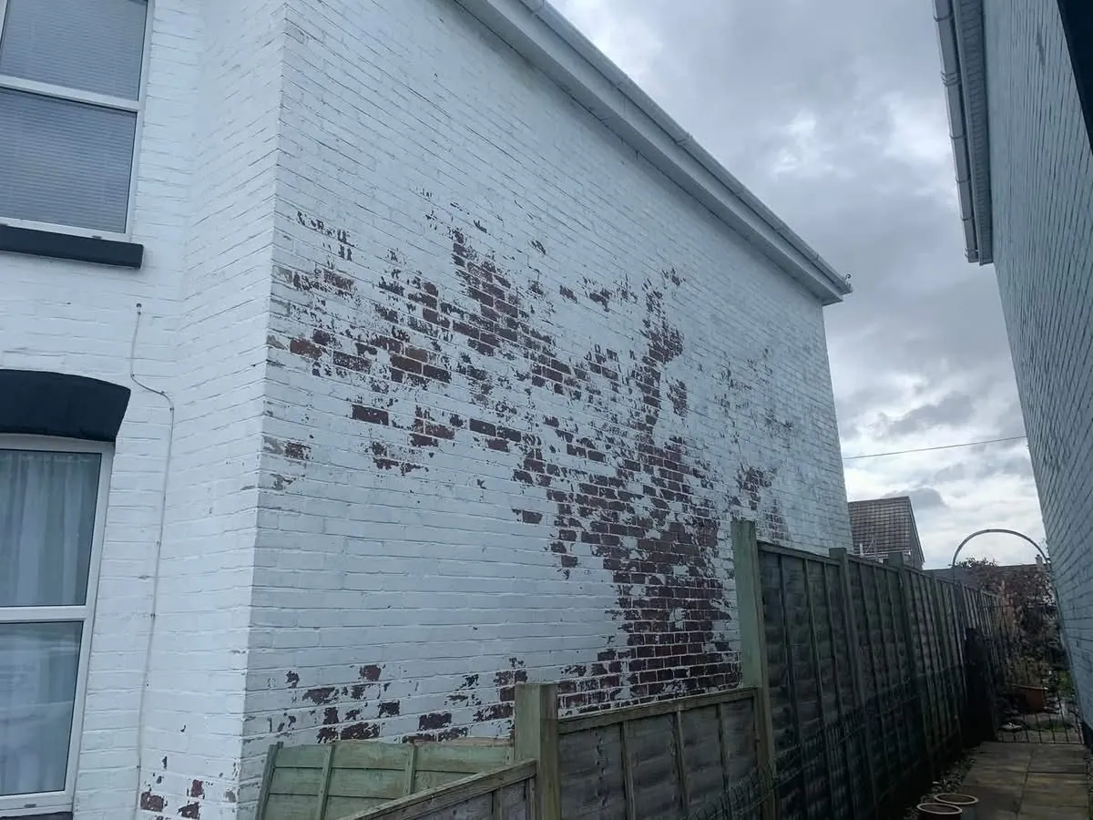 Peeling paint on a brick wall before redecoration in Penryn